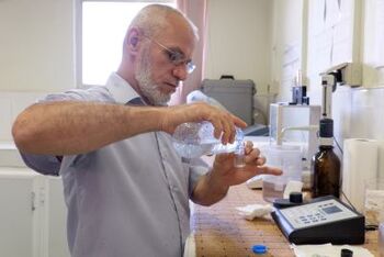Examining water samples in Kharabdeen laboratory.