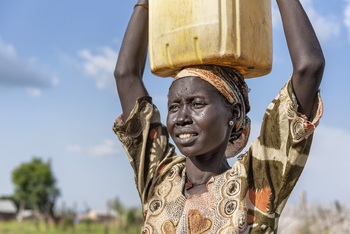 Woman carries water canister