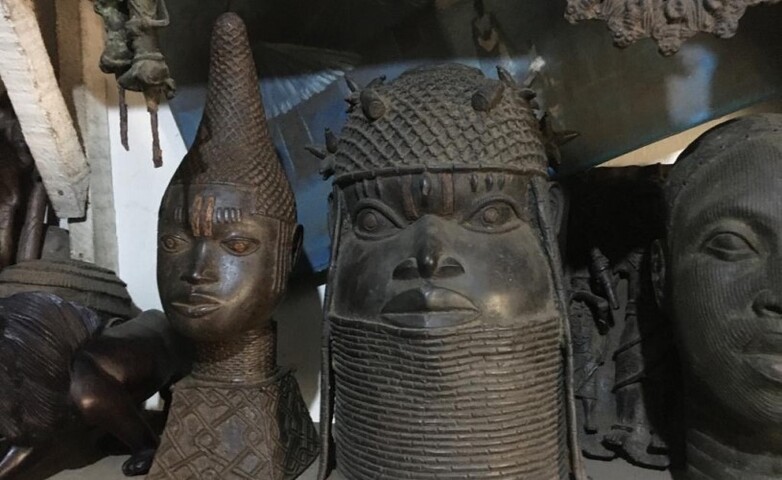 Several bronze artefacts stand on a shelf.