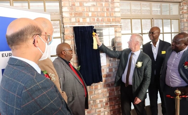 H.E. Ambassador Herbert Beck unveiling the official plaque at Valombola VTC during the inauguration of a new training workshop for automotive mechatronics.