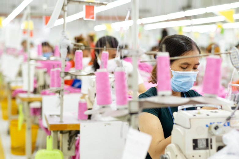 Workers at sewing machines in a production facility. Copyright: Roman Koenig