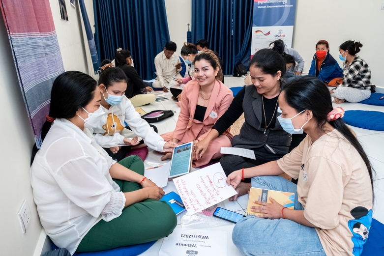 Employees sitting in groups as they work together during a training session. Copyright: Roman Koenig