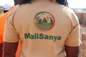A woman wears a uniform MaliSanya t-shirt. 
