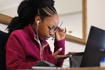 A young woman sits at a computer