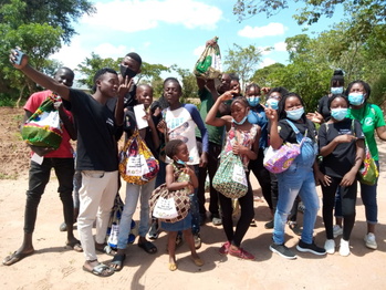 Project participants stand together and display their bags, which are filled with hygiene articles and information materials. Copy-right: GIZ