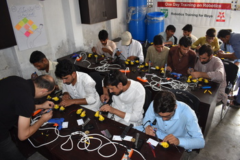 Young men taking part in a robotics course. Copyright: GIZ