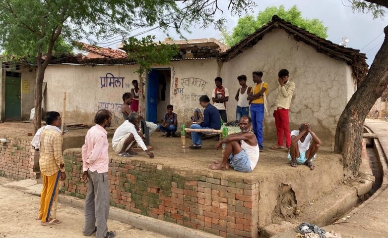 A group of people gathers in front of a house.