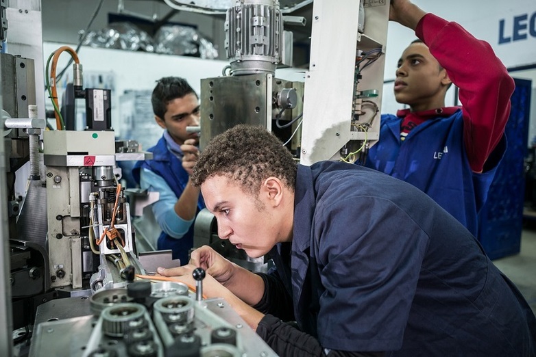 Three apprentices having their training in industrial mechanics / cable manufacturing