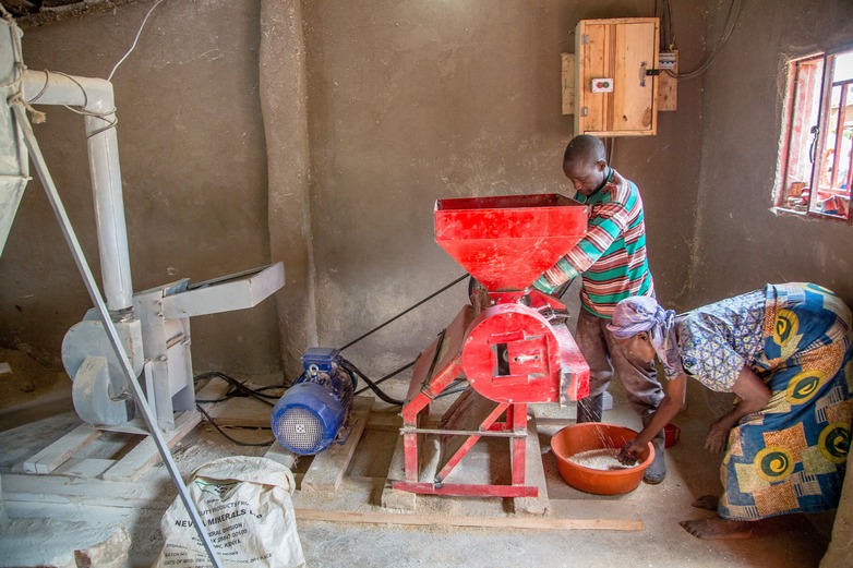 A man and woman use an electrically operated mill. © GIZ