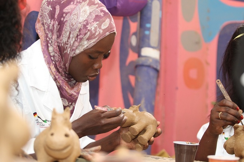 Une femme façonne une forme animale dans le cadre d'une formation à l'artisanat à Dakar. Copyright : GIZ/Diop.