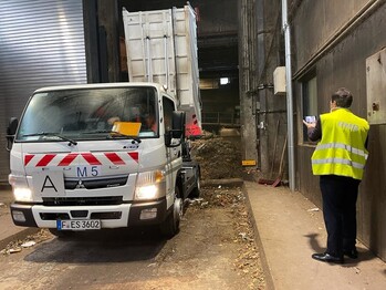 A lorry unloads waste at an organic composting plant.