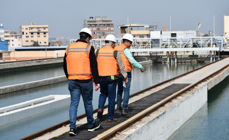 Three workers at a sewage treatment plant