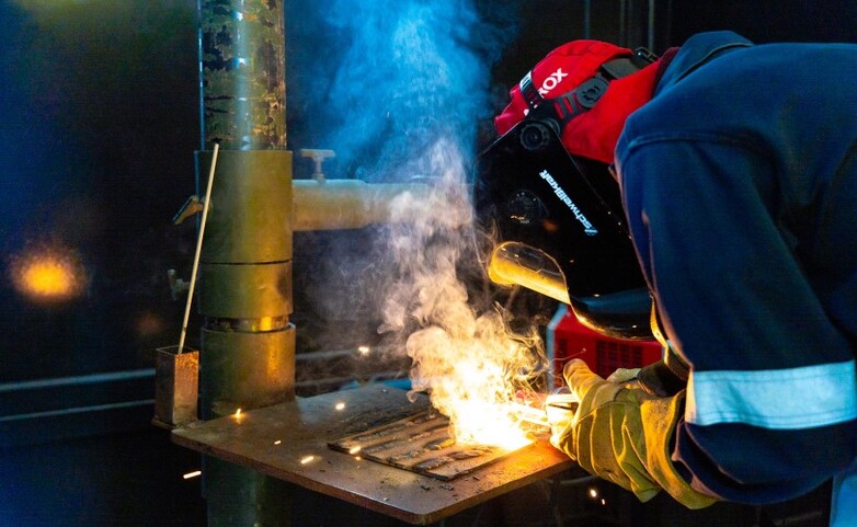A person welding a piece of metal.
