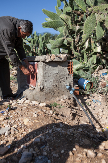 Un agriculteur travaille à un point de distribution d’eau pour l’irrigation.