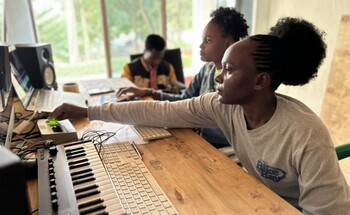 Two women work in a recording studio.