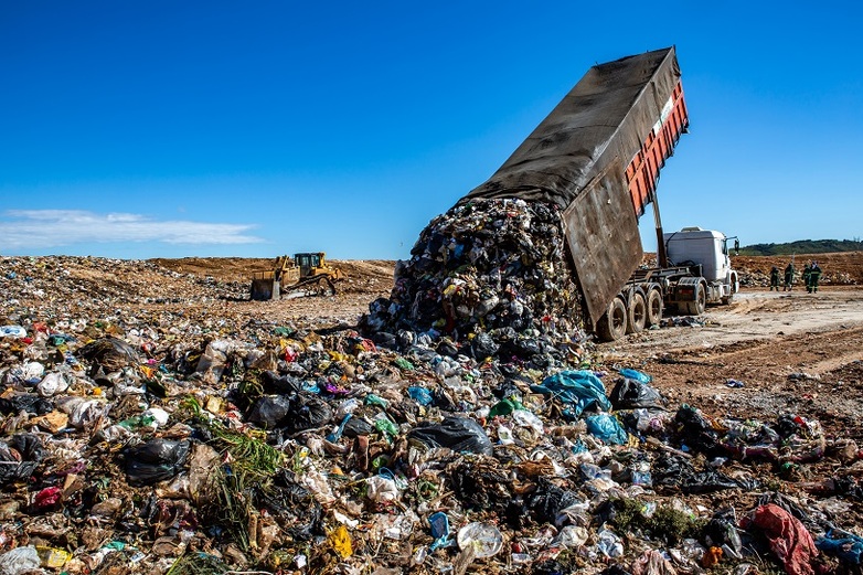 Truck pours garbage onto a landfill