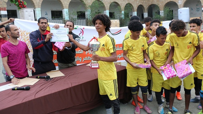 Traumatised young people who have received psychological support through the project are awarded the trophy at a football tournament (source: IYSO)