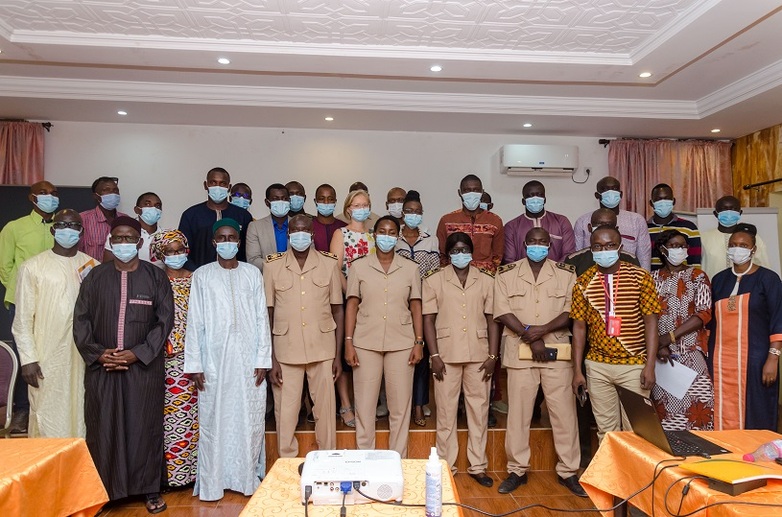 Group photo in which thirty people pose with masks and some in work uniforms.
