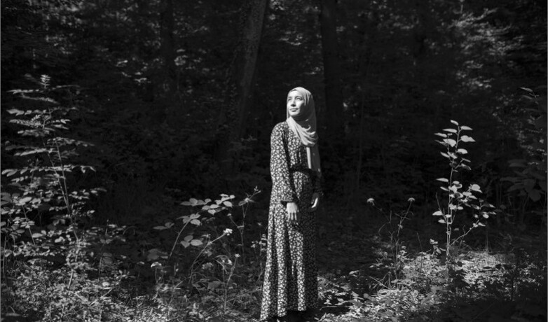 A black-and-white photo showing a young Iraqi women in nature