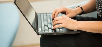 Two hands are working on the keyboard of a laptop.