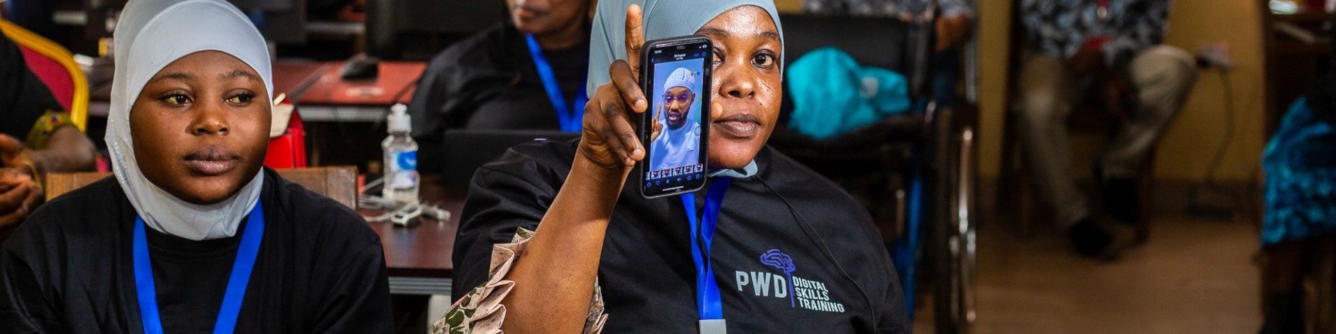A woman showing a smartphone with a video during a training session for women micro-entrepreneurs. © GIZ