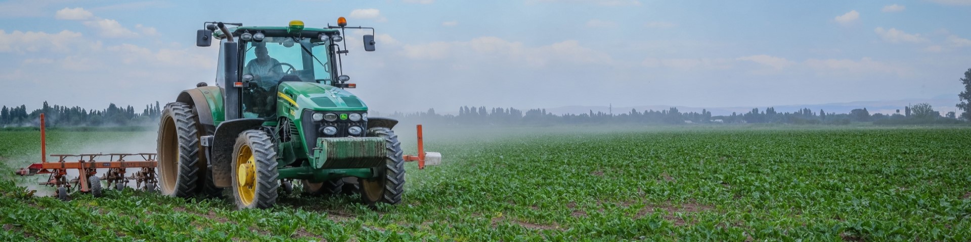 A tractor sprays water onto an agricultural field.