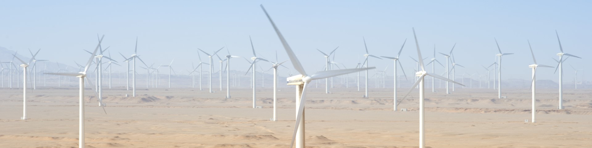 A vast array of wind turbines standing in the desert, harnessing the power of wind to generate clean and renewable energy.
