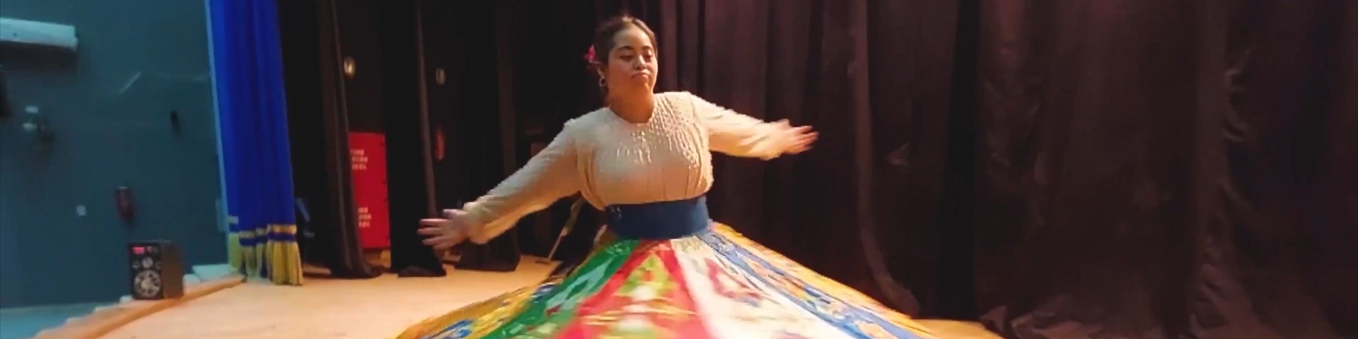 A dancer with Down’s syndrome spins so fast that her long skirt flies.
