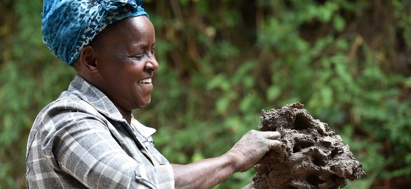 Kenyan woman forms clay for cooking stoves