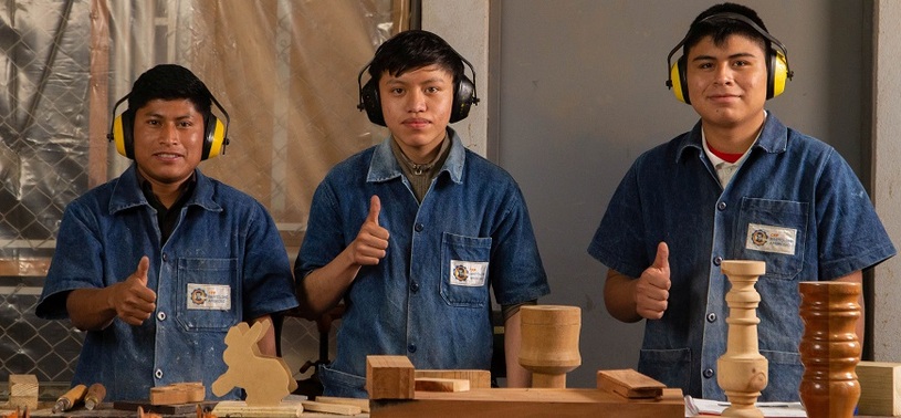 A group of men wearing headphones and giving thumbs up.