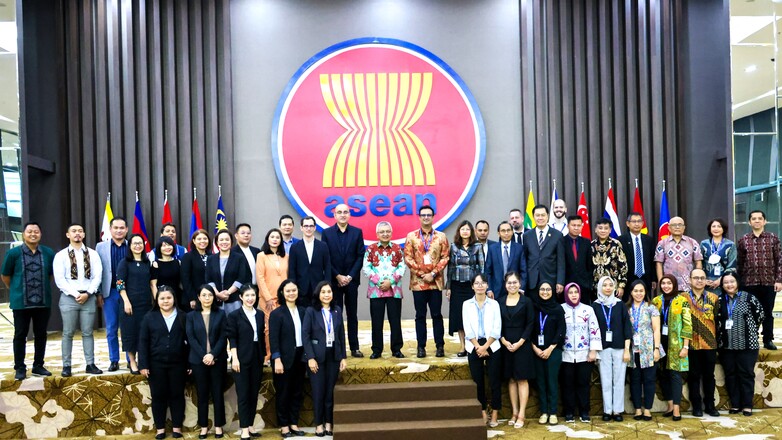 A group of people in front of a curtain.