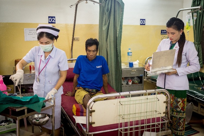 In Laos two medical specialists treat a patient who has been bitten by a poisonous snake.