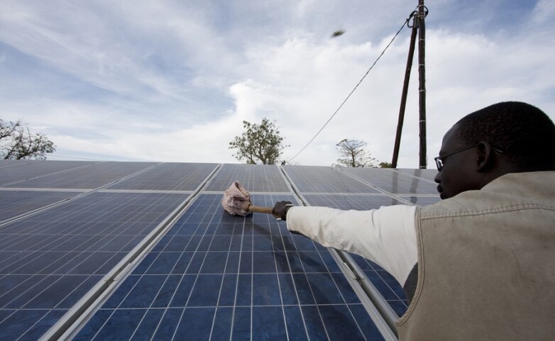 A technician does maintenance work on a solar plant. © GIZ