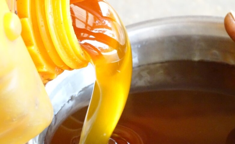Du miel est versé dans un bol.