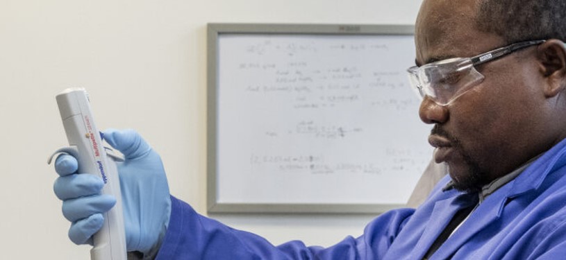 A man in a laboratory holds a measuring device in his hand.