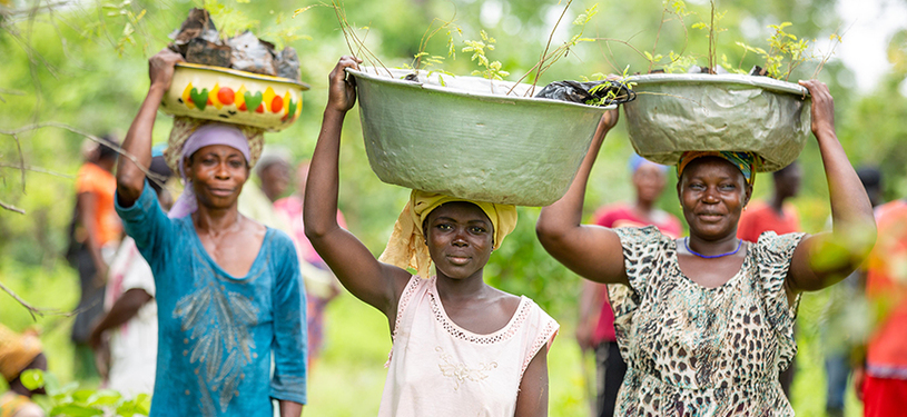 Three women carrying bowl on head.