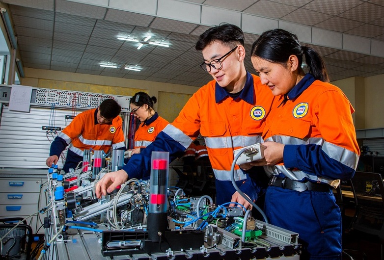 Young people in protective clothing work in partner groups on a technical test setup in a mechatronics training course in Darkhan-Uul province in Mongolia.