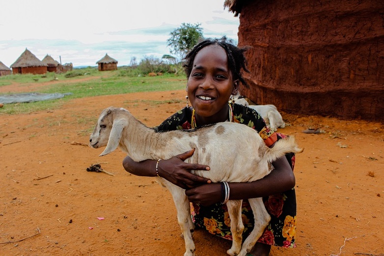 Girl with a young goat. ILRI Camille Hanotte