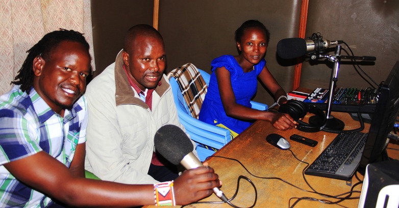 Three radio journalists are sitting in a radio station.