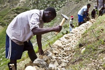 Re-afforestation measure: Stone walls for erosion protection are built with the help of the local mountain population along contour lines. © GIZ
