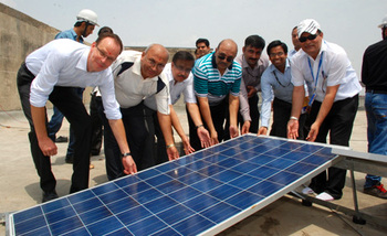 India. Representatives from GIZ, DMRC and SunEdison installing the first module on site  © GIZ