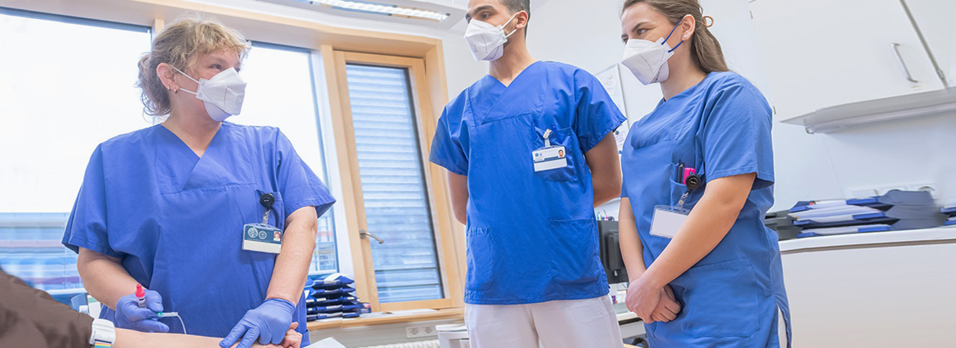 A group of people wearing scrubs and face masks.