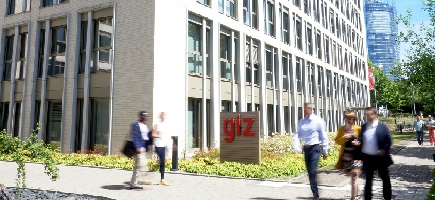 People in front of an office building with a GIZ sign outfront.